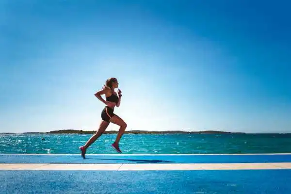 Woman running showing strong leg muscle Waltham Forest